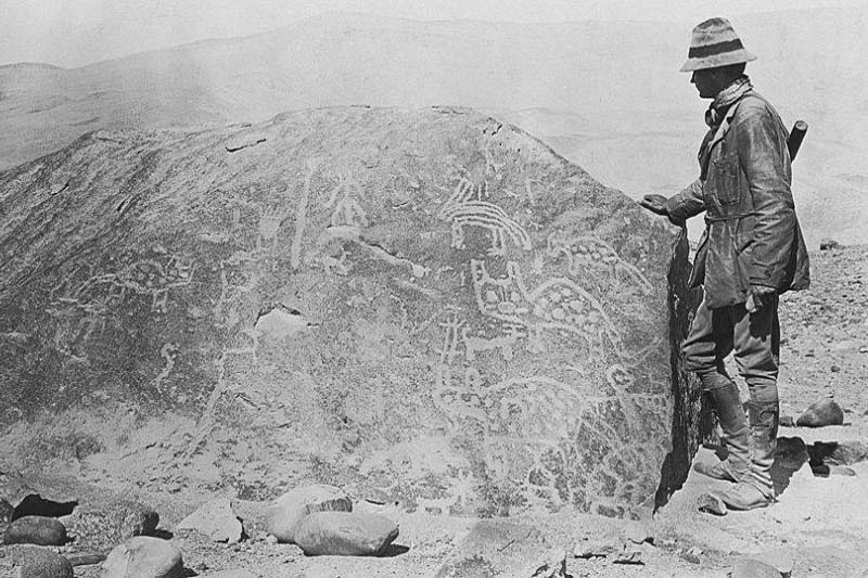 Hiram Bingham checking a petroglyph, during his expedition to Machu Picchu