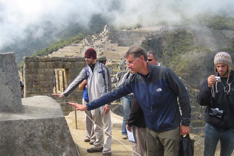 Energy in Machu Picchu Tourists trying to feel the energy emitted by the Intihuatana in Machu Picchu