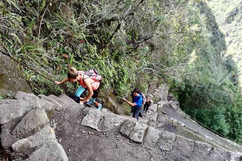 Tourists climbing Huayna Picchu mountain by the stairs of death